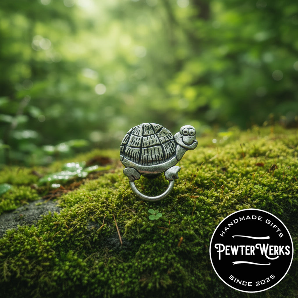 A Pewter 'Cartoon Turtle' eyeglass holder foraging in the forest on a bed of moss. PewterWerks logo visible.