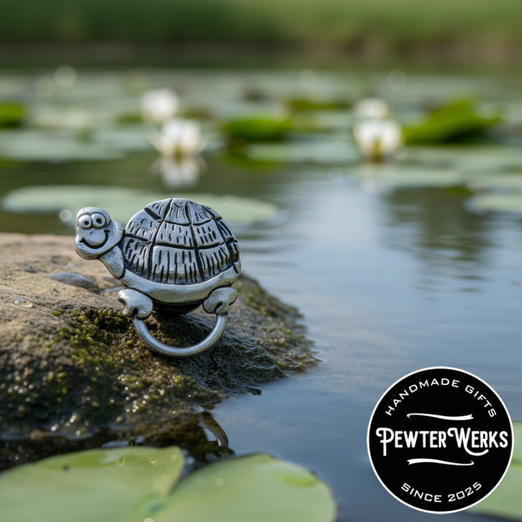 A pewter 'Cartoon Turtle' eyeglass holder climbing out of a pond on onto a rock. PewterWerks logo is visible.