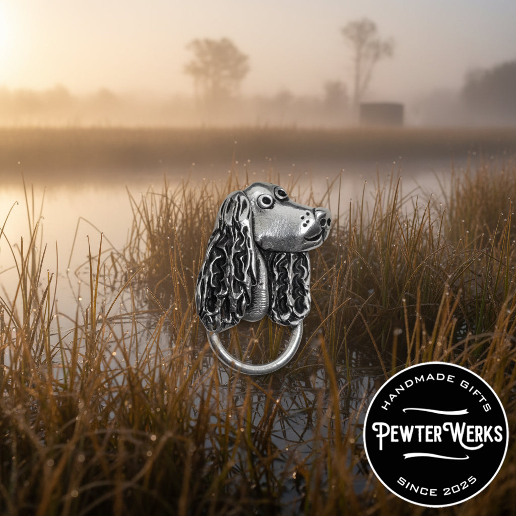 A Pewter 'Dog a Spaniel' eyeglass holder hiding in the marsh hunting ducks On a gloomy and foggy day. PewterWerks logo visible.
